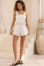 Women in white playsuit with drawstring waist and lacing detail full body shot
